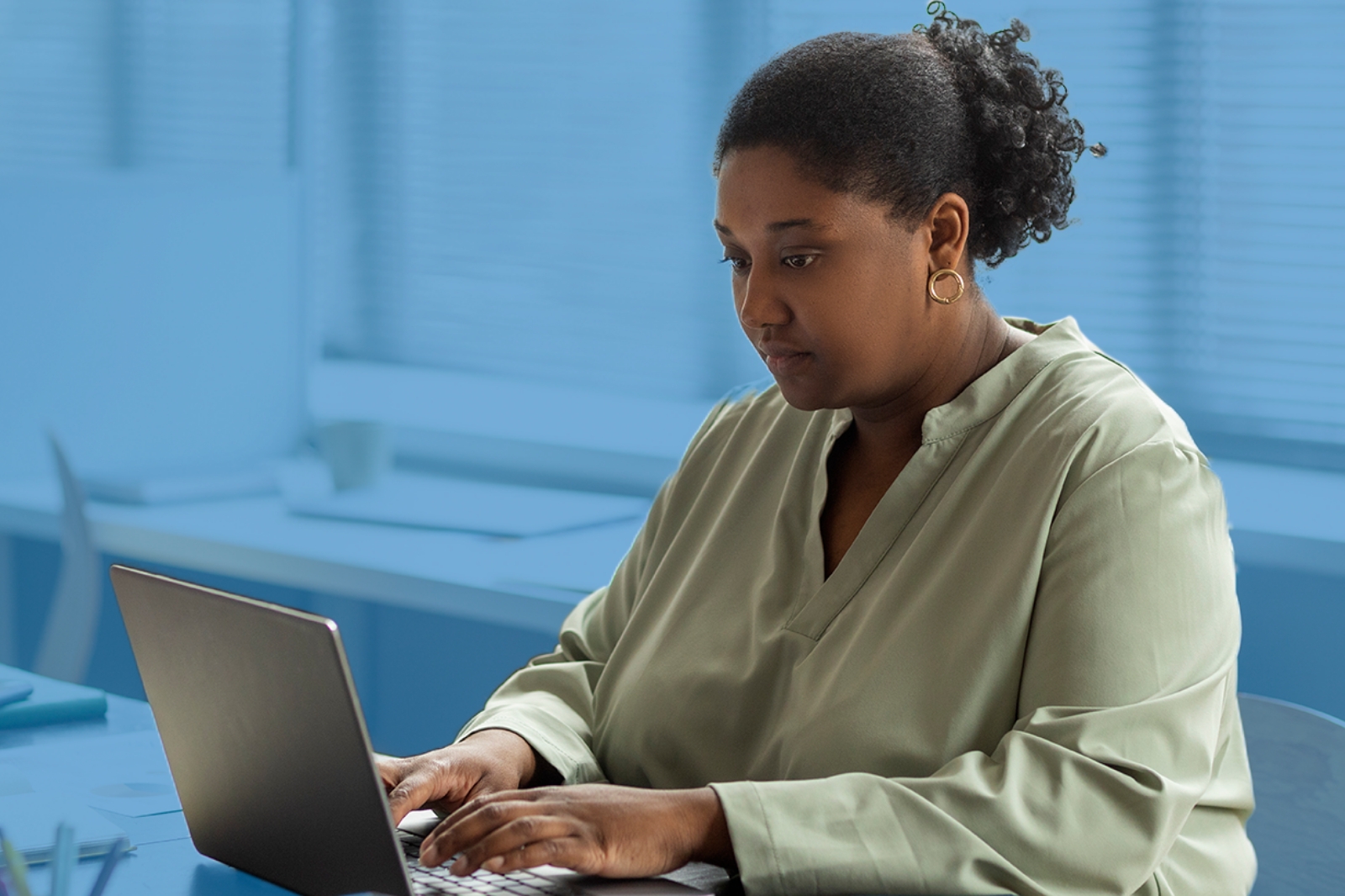a woman sitting at a desk using a laptop